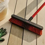 Nettoyer terrasse en composite : eau savonneuse et brosse en gros plan